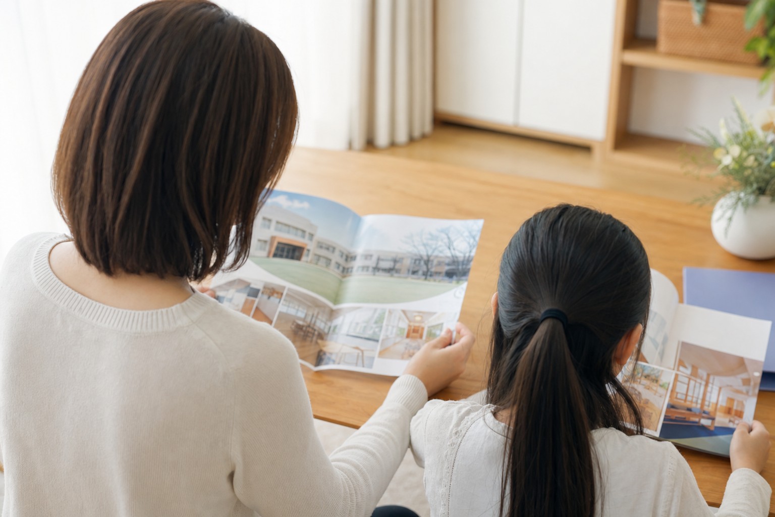 親子で学校案内パンフレットを見る後ろ姿
