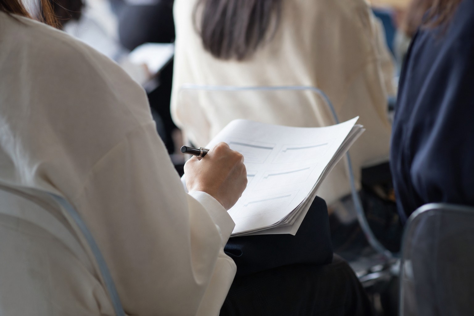 保護者会の資料にメモを書き込む手元