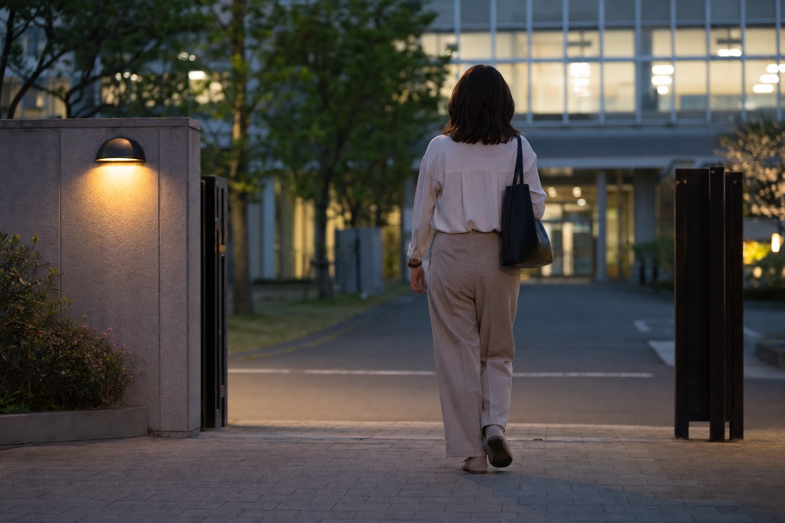 夕方の校舎前を歩いて帰る保護者の後ろ姿