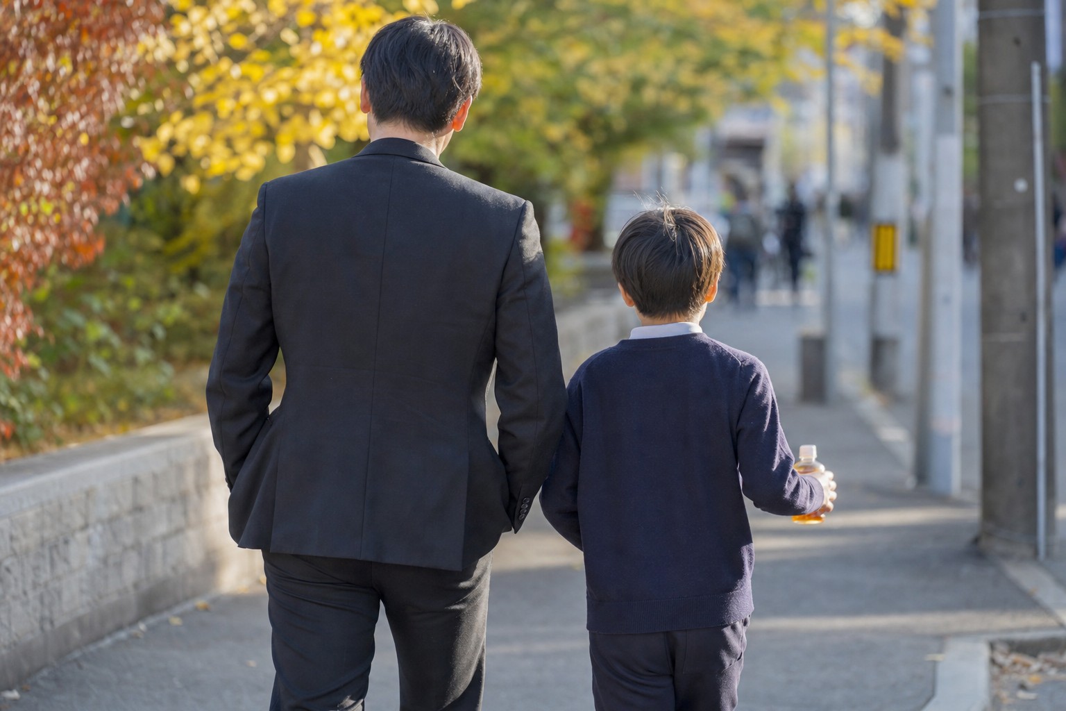 テスト帰りに並んで歩く親子の後ろ姿
